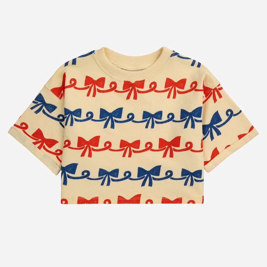 Bobo Choses - pale yellow cropped sweatshirt with all over ribbon bow print in red and blue