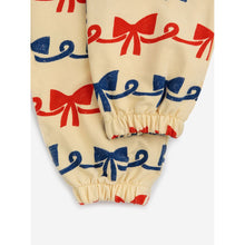Load image into Gallery viewer, Bobo Choses - beige sweatpants with all over ribbon bow print in red and blue
