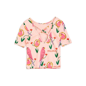 Mini Rodini - pink ballet style top with all over parrot print and cross straps on back