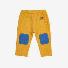 Load image into Gallery viewer, Bobo Choses quilted baby trousers in mustard yellow with blue patched knees from the new AW24 collection &#39;Once Upon A Time&#39;
