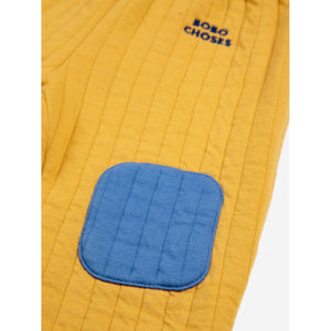 Bobo Choses quilted baby trousers in mustard yellow with blue patched knees from the new AW24 collection 'Once Upon A Time'