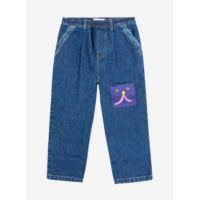 Bobo Choses blue denim trousers with funny face patch from the new AW24 collection 'Once Upon A Time'