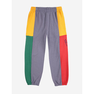 Color-blocked pants with gray, yellow, green, and red sections on a white background