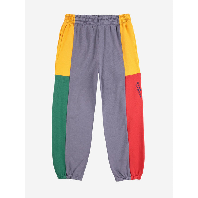 Color-blocked pants with gray, yellow, green, and red sections on a white background