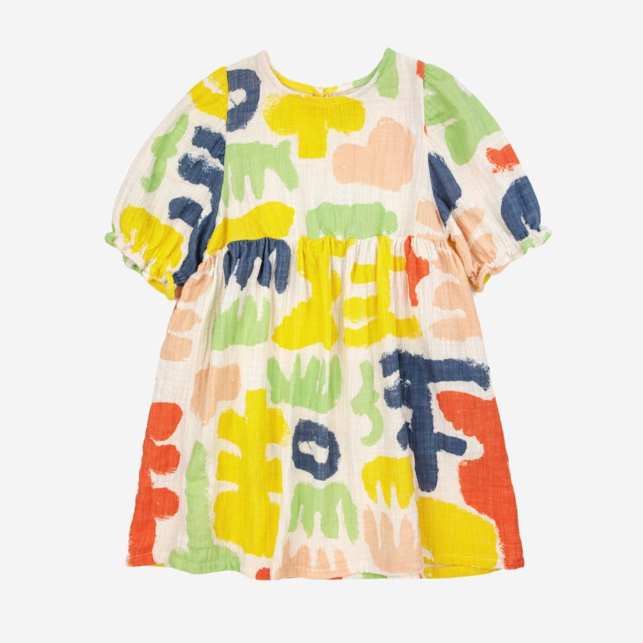 Bobo Choses - off white muslin dress with all over abstract carnival print in yellow, red, green and blue