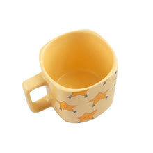 Load image into Gallery viewer, Tinycottons - pale yellow ceramic mug with all over dancing stars design in darker yellow
